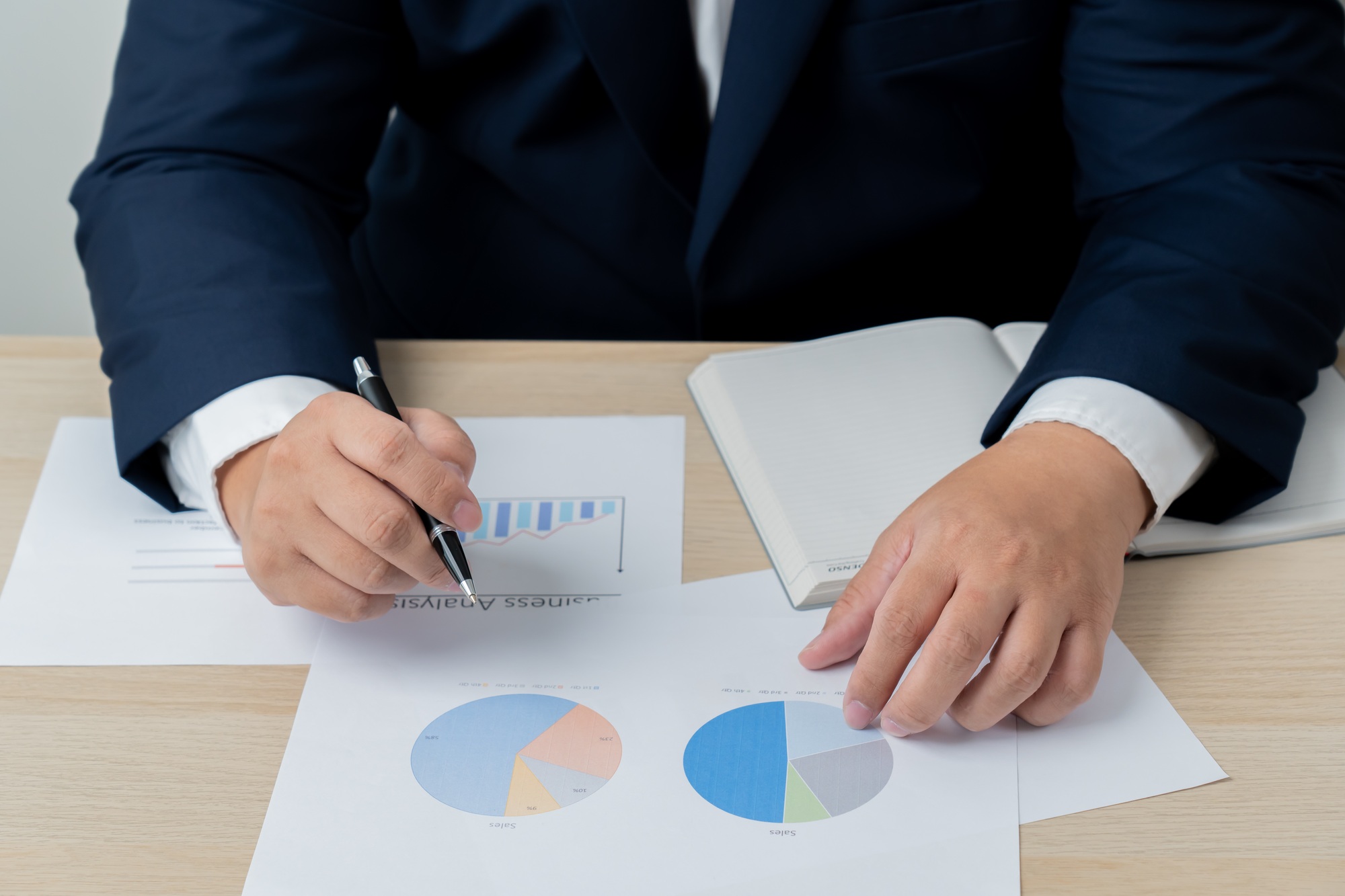 Business man analyzing financial document graph report paper