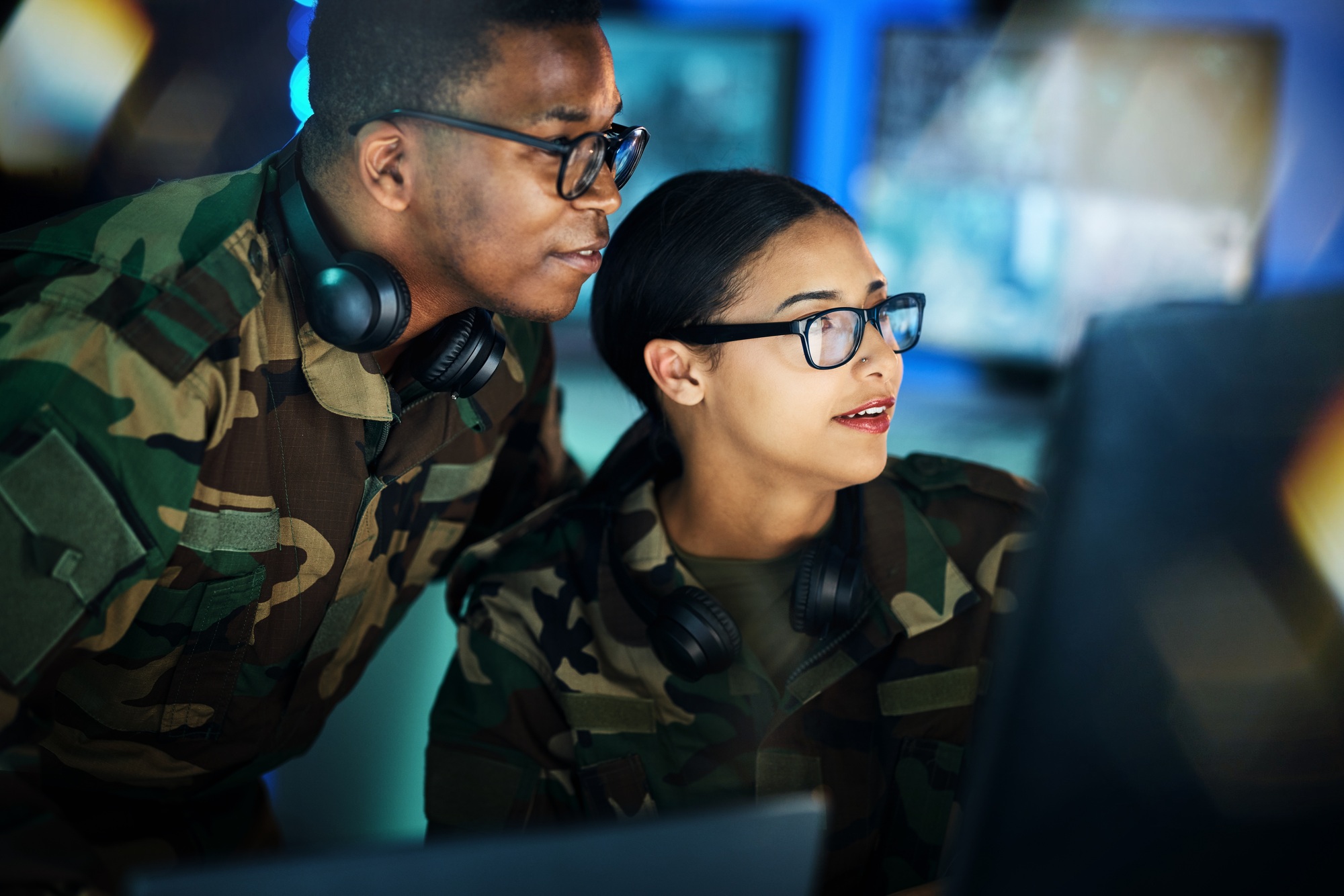 Military, surveillance and people with computer talking in office for cybersecurity, communication