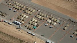 An overhead aerial shot of a military base in the desert.